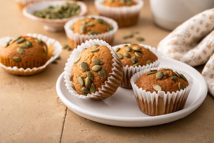 Three pumpkin muffins on a white plate