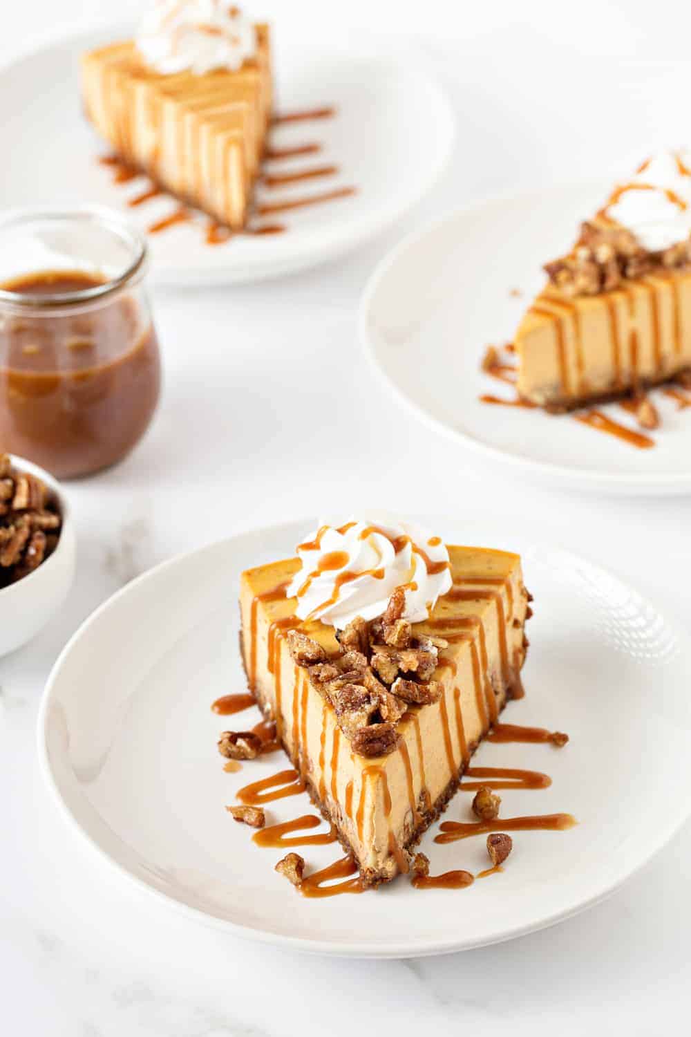 Pumpkin Praline Cheesecake combines sweet praline pecans with creamy pumpkin cheesecake, a gingersnap crust and salted caramel sauce. 