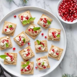 Hummus-Pomegranate TRISCUIT Toppers use just a handful of ingredients – hummus, feta and pomegranate seeds – to create a fun party snack for all ages!