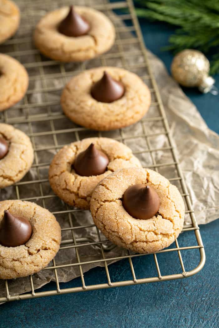 Peanut butter blossoms arranged on a wire cooling rack over a piece of parchment paper