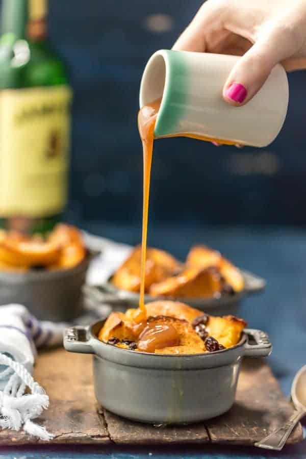 Caramel sauce being poured over a ramekin of irish bread pudding.