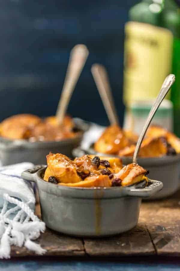 Spoon in a ramekin of irish bread pudding topped with whiskey caramel sauce.