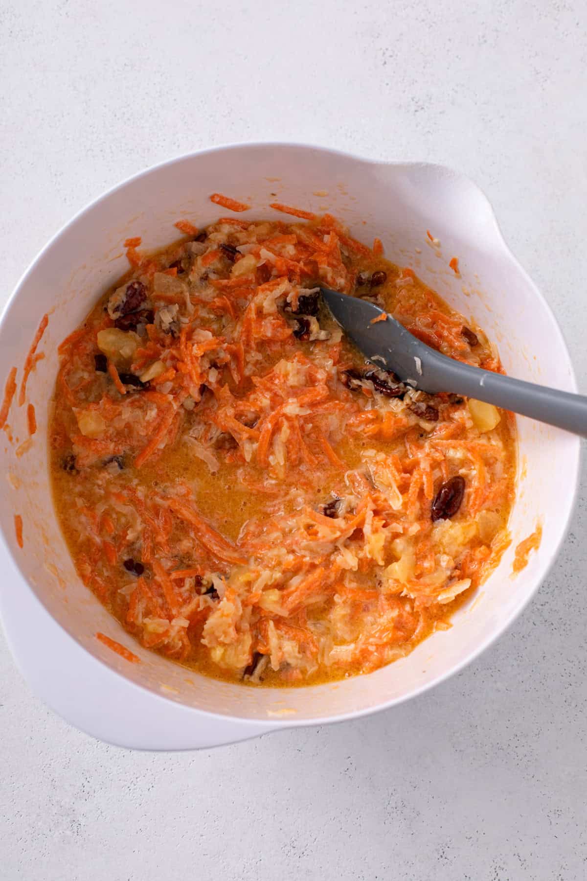 Wet ingredients for j alexander's carrot cake mixed in a white mixing bowl.
