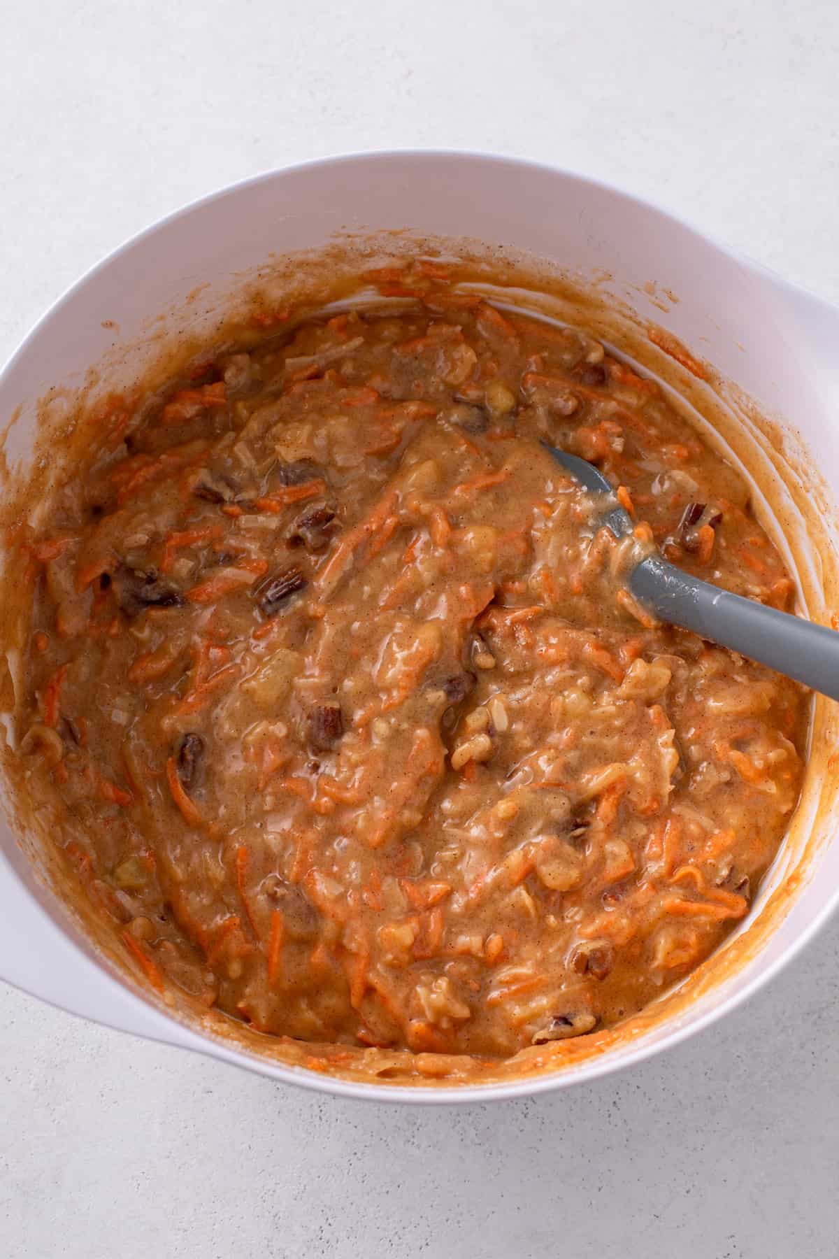 Batter for j alexander's carrot cake mixed in a white mixing bowl.