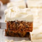 Slice of j. alexander's carrot cake being lifted up with a cake server.