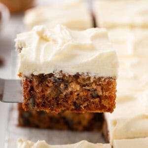 Slice of j. alexander's carrot cake being lifted up with a cake server.