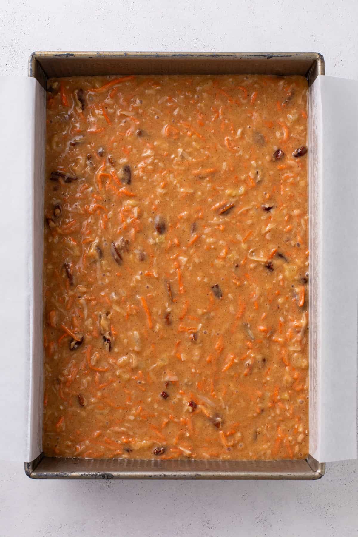 Batter for j alexander's carrot cake spread into a 9x13-inch pan.