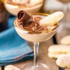 Tiramisu martini in a coupe glass surrounded by ladyfinger cookies