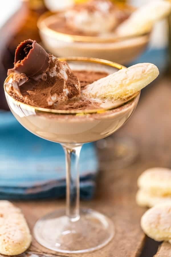 Tiramisu martini in a coupe glass garnished with a ladyfinger cookie and chocolate curl
