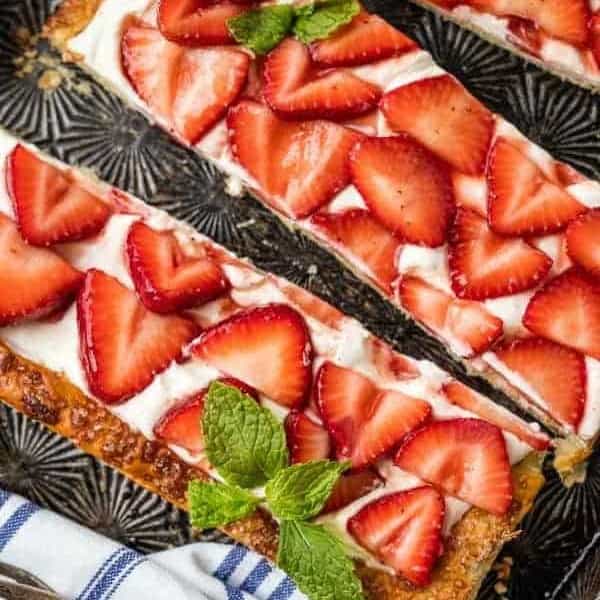 Slices of puff pastry strawberry tart garnished with mint