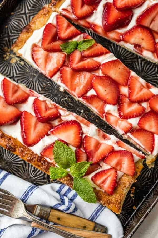 Slices of puff pastry strawberry tart garnished with mint