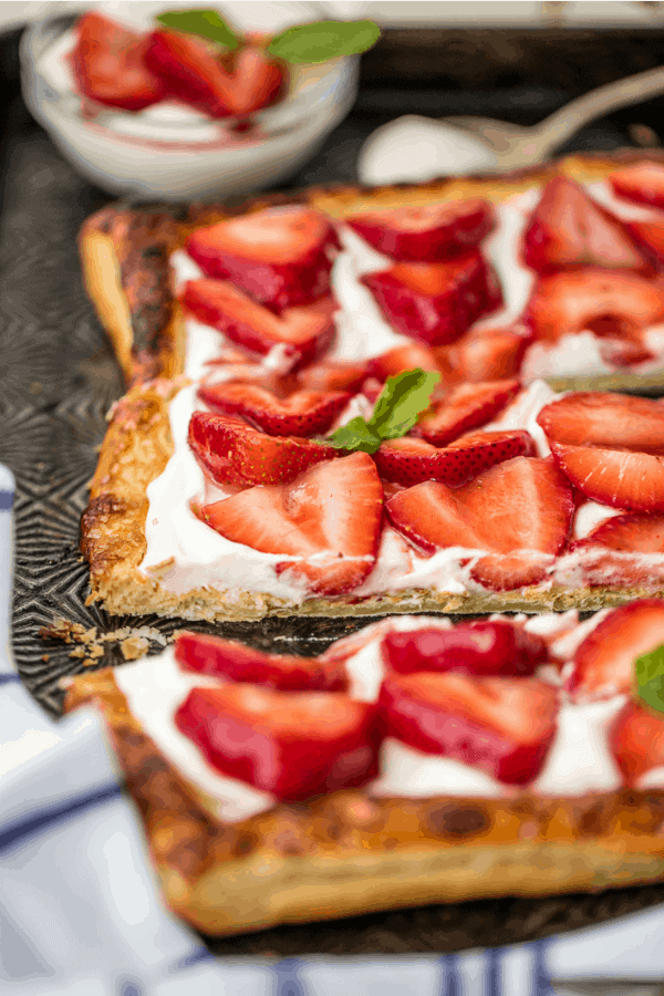 Sliced strawberries topping a puff pastry tart shell and mascarpone filling