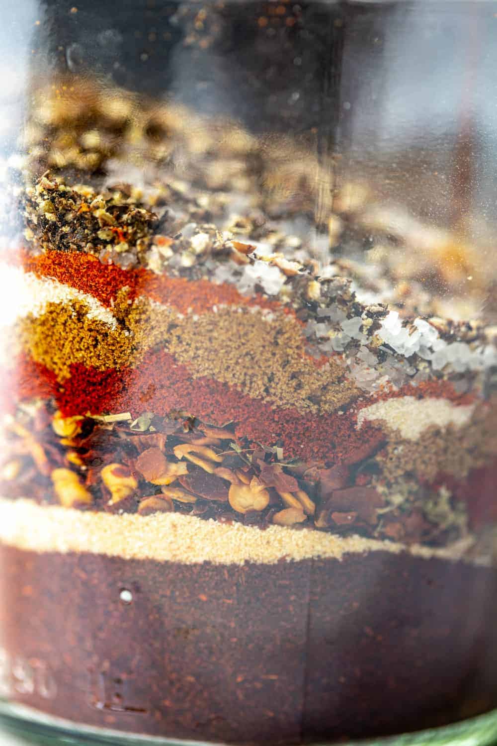close-up view of chili seasoning spices layered in a jar