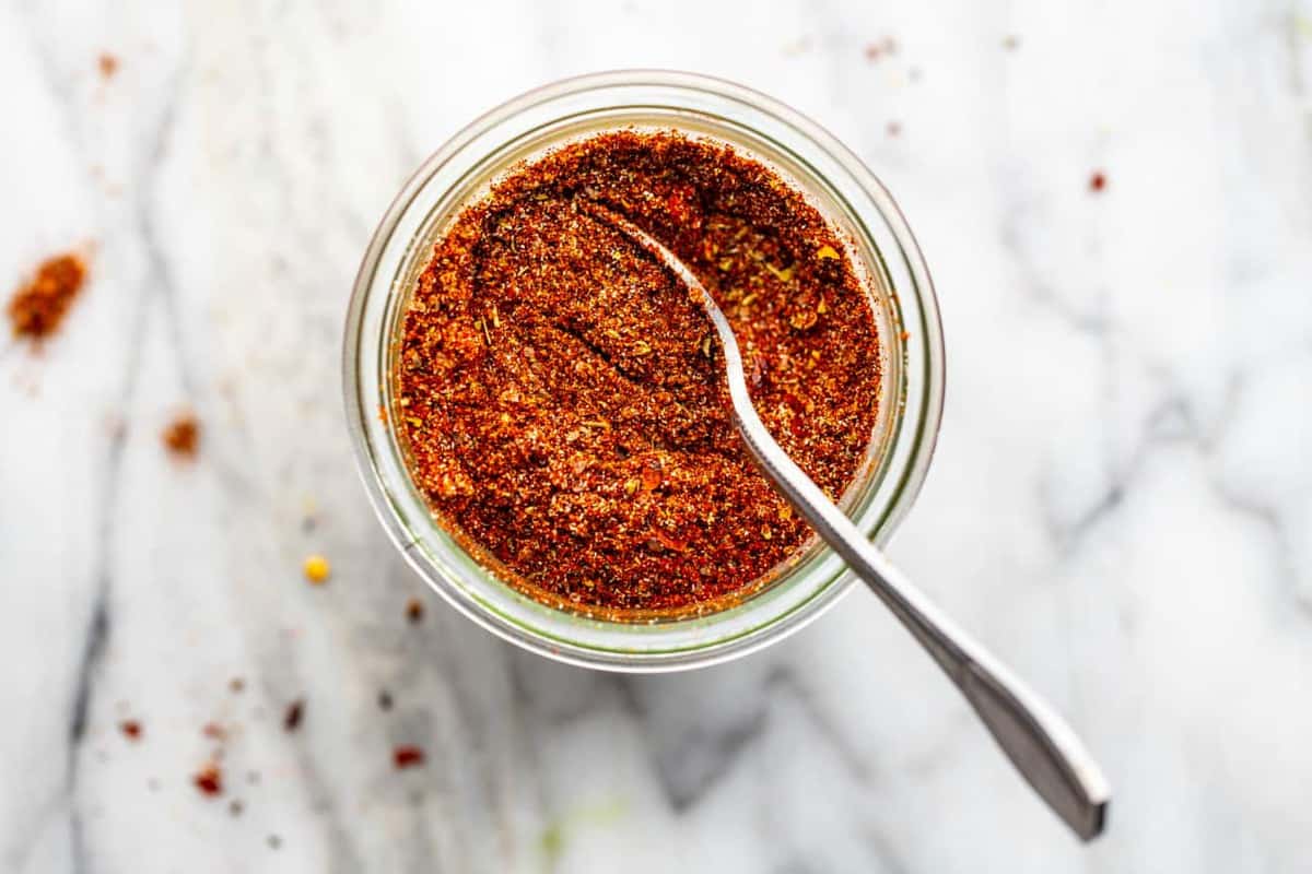 spoon mixing up a jar of homemade chili seasoning