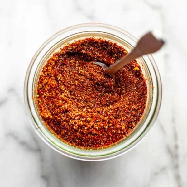 spoon mixing up a jar of homemade taco seasoning