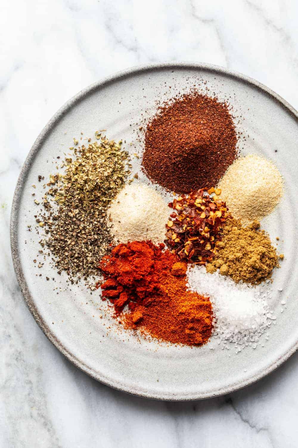 Spices for homemade taco seasoning arranged on a plate