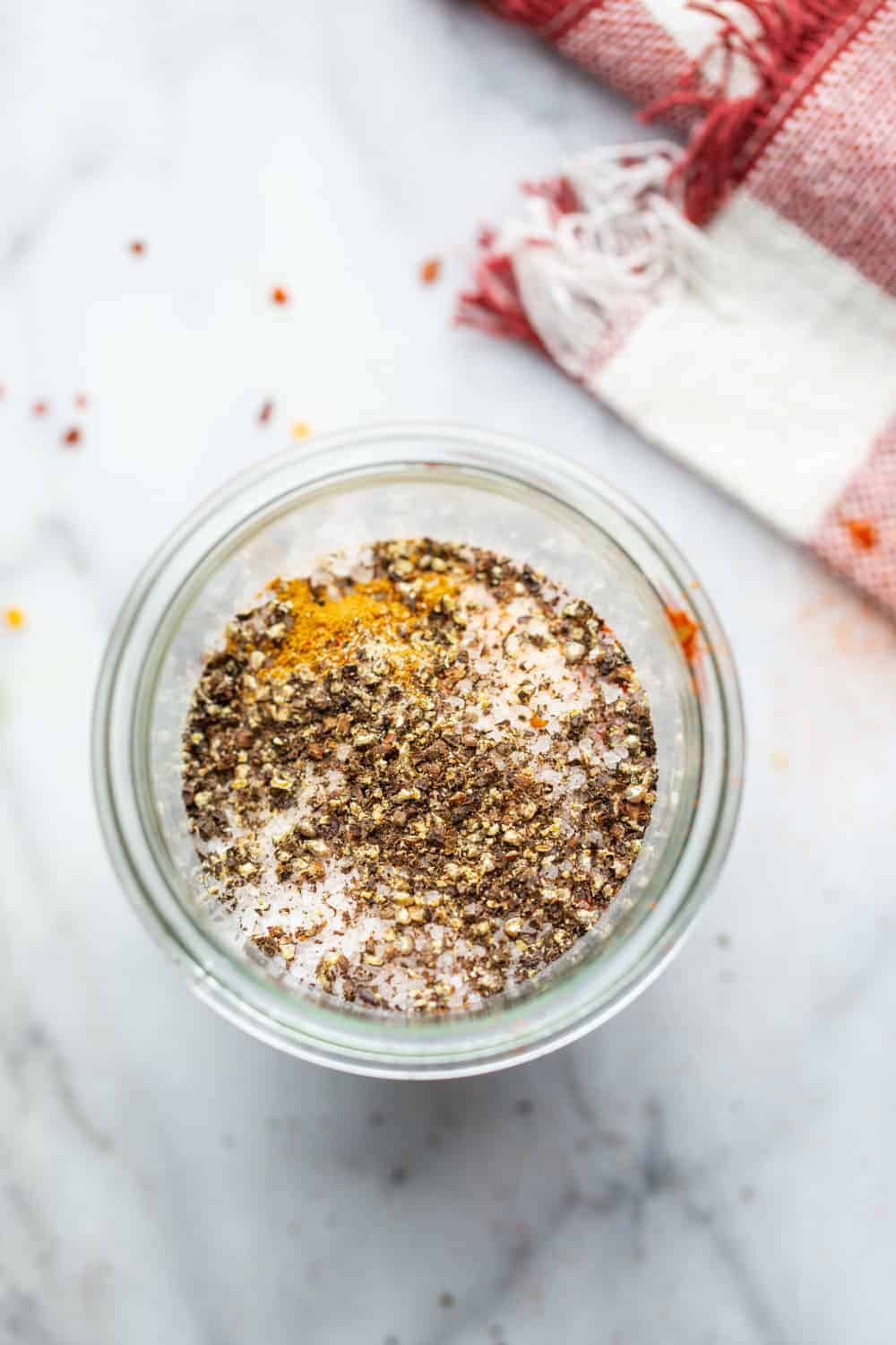 open jar with spices for taco seasoning on a marble surface