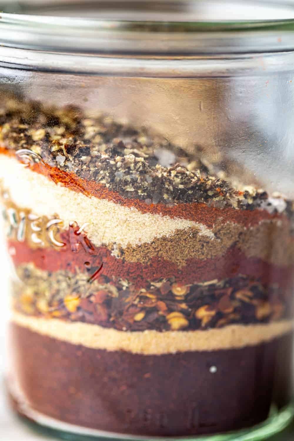 close-up view of spices for homemade taco seasoning layered in a jar