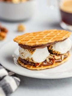 Plated s'more made with waffle cookies, chocolate hazelnut spread and 2 large roasted marshmallows