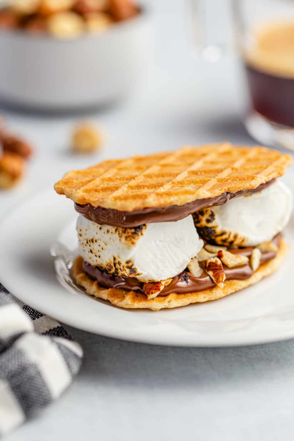 Plated s'more made with waffle cookies, chocolate hazelnut spread and 2 large roasted marshmallows