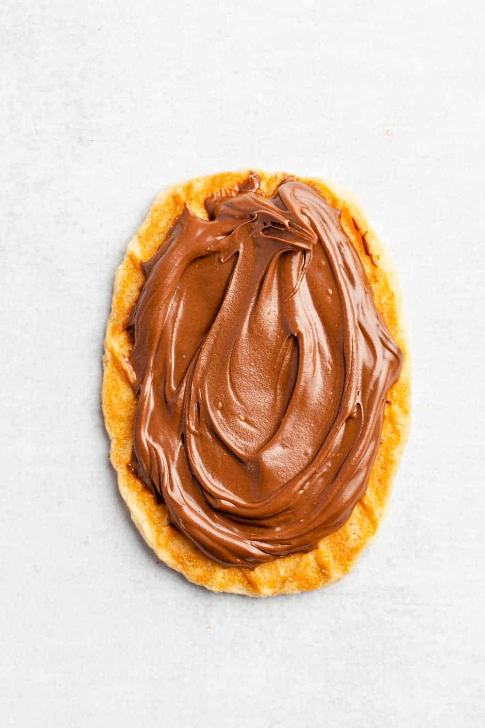 Overhead view of waffle cookie topped with chocolate hazelnut spread