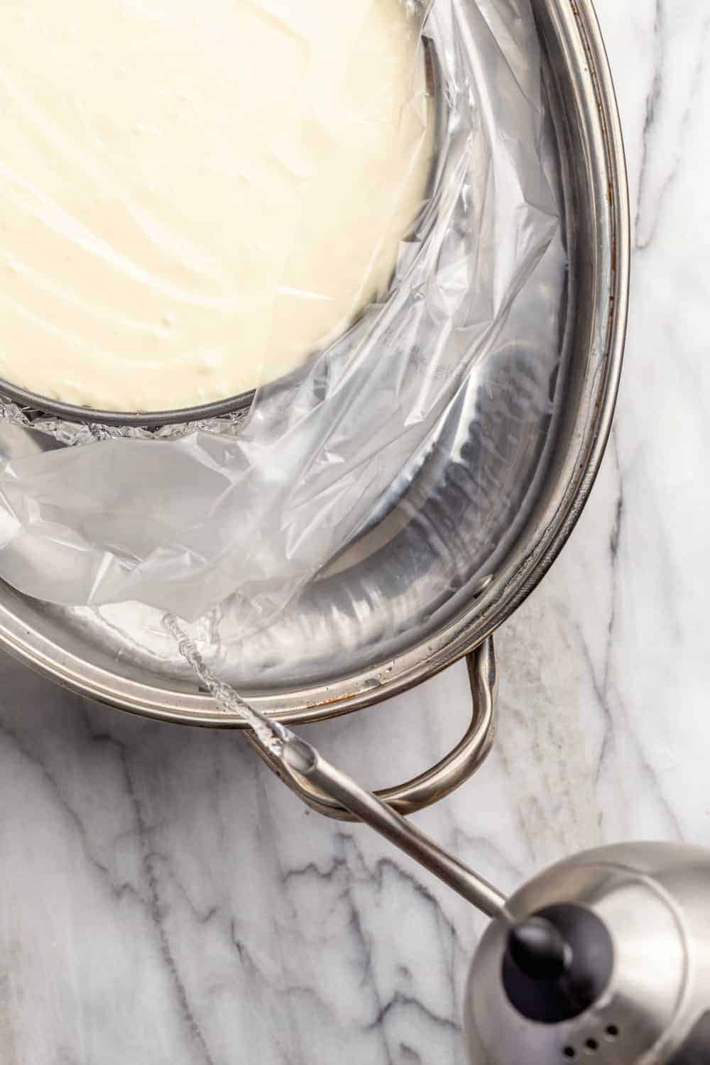 Adding boiling water to a roasting pan for a water bath