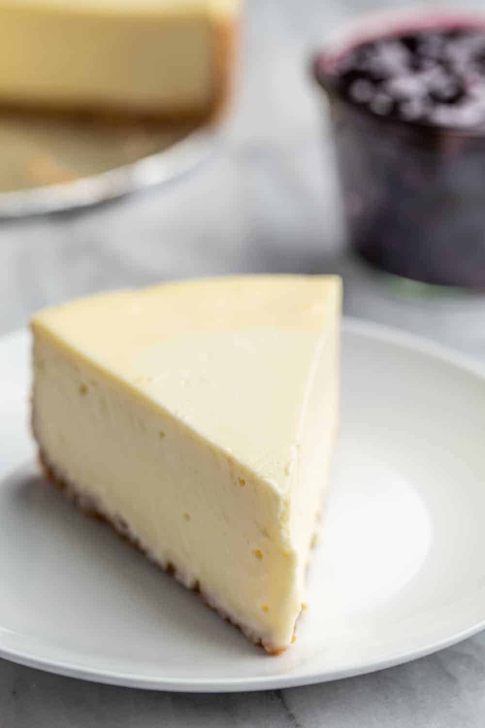 Slice of plain vanilla cheesecake on a white plate