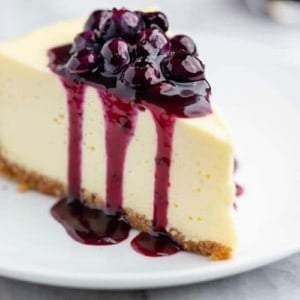 Slice of vanilla cheesecake topped with blueberry sauce