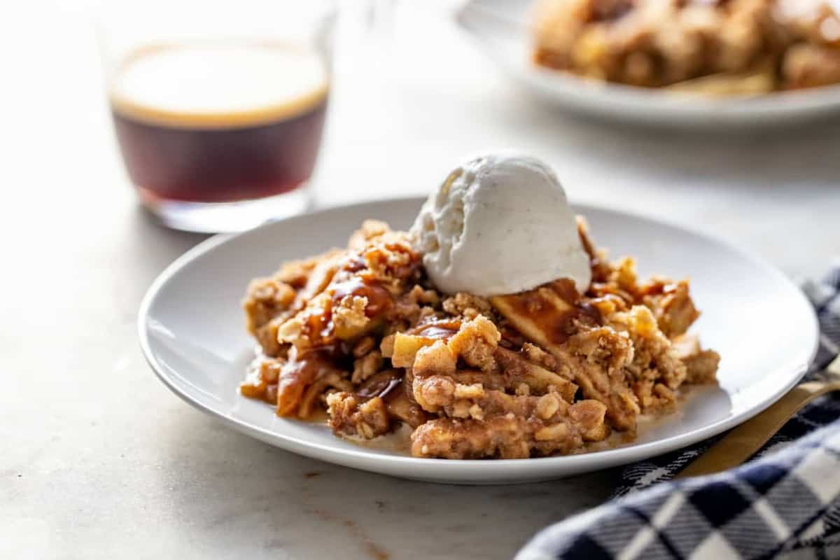 Caramel apple crisp topped with vanilla ice cream, ready to be served