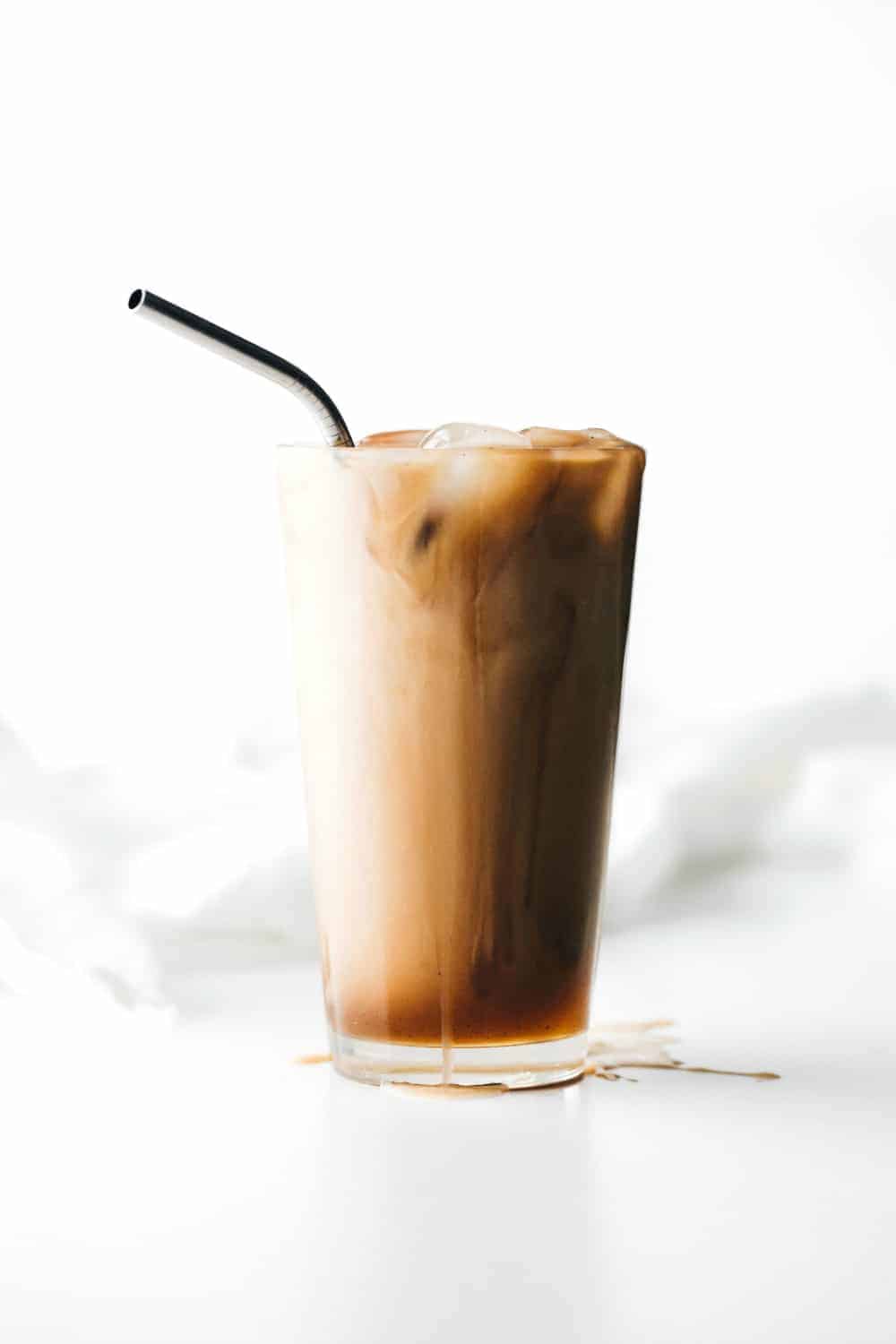 Glass of vanilla iced coffee with a straw