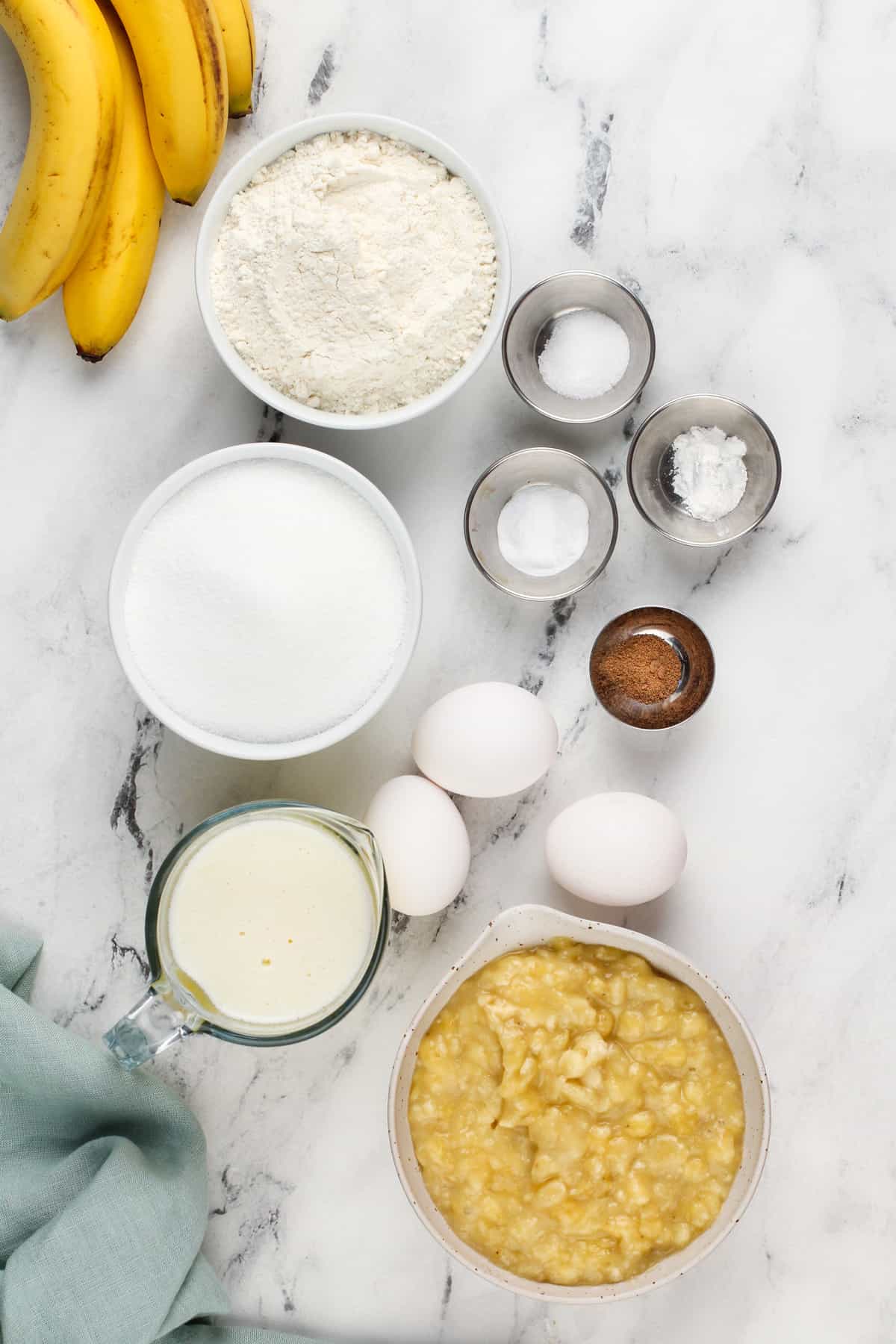 Ingredients for dominique ansel's banana bread arranged on a marble countertop.