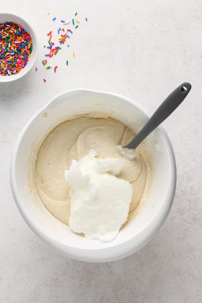 Folding egg whites into white cake batter.