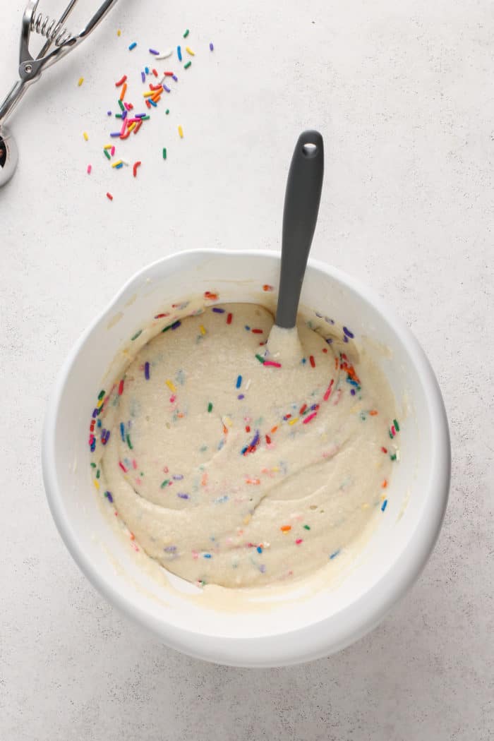 Funfetti cupcake batter in a white mixing bowl.