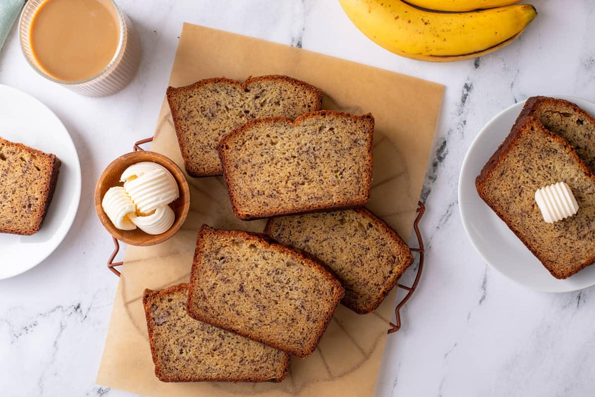 Overhead view of slices of dominique ansel's banana bread arranged on a piece of parchment paper.