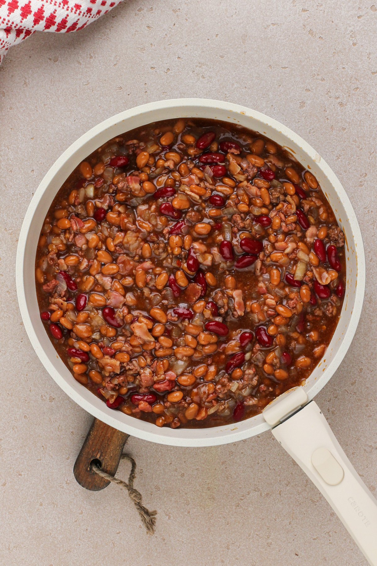 Easy baked beans mixed in a skillet, ready to go in the oven.