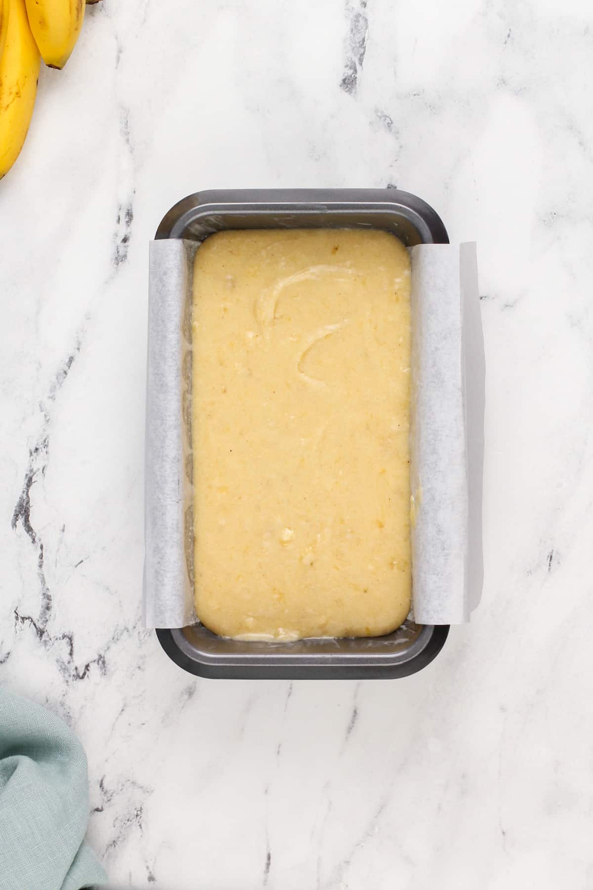 Batter for dominique ansel's banana bread in a loaf pan, ready to go in the oven.