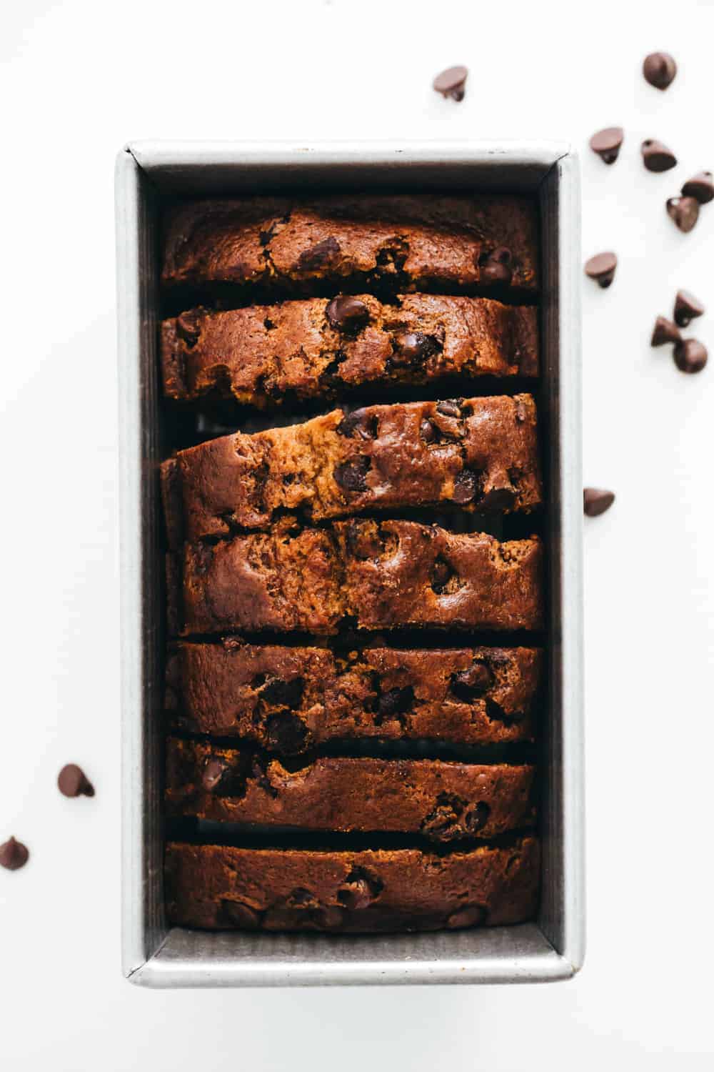 Slices of pumpkin chocolate chip bread in a loaf pan