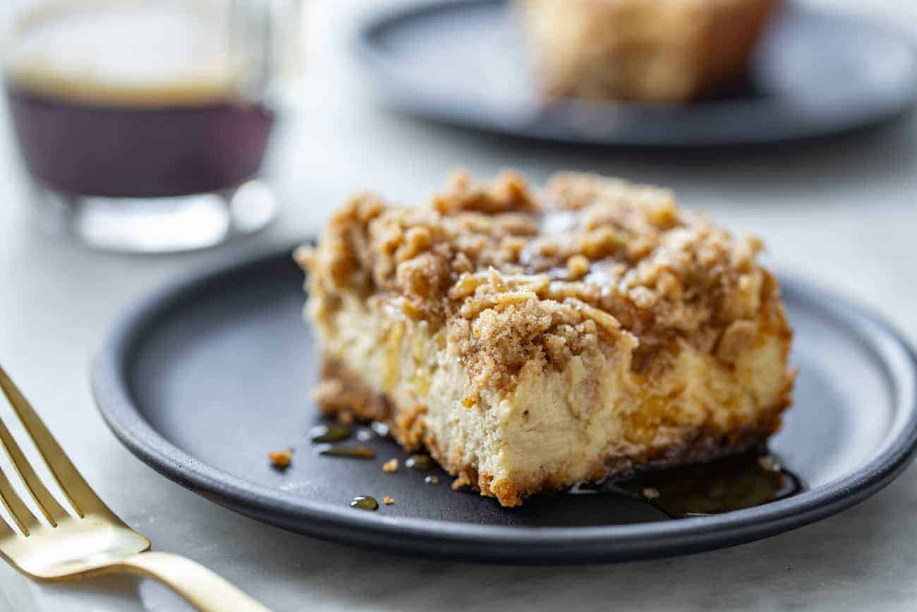 Slice of maple streusel cheesecake bar on a black plate