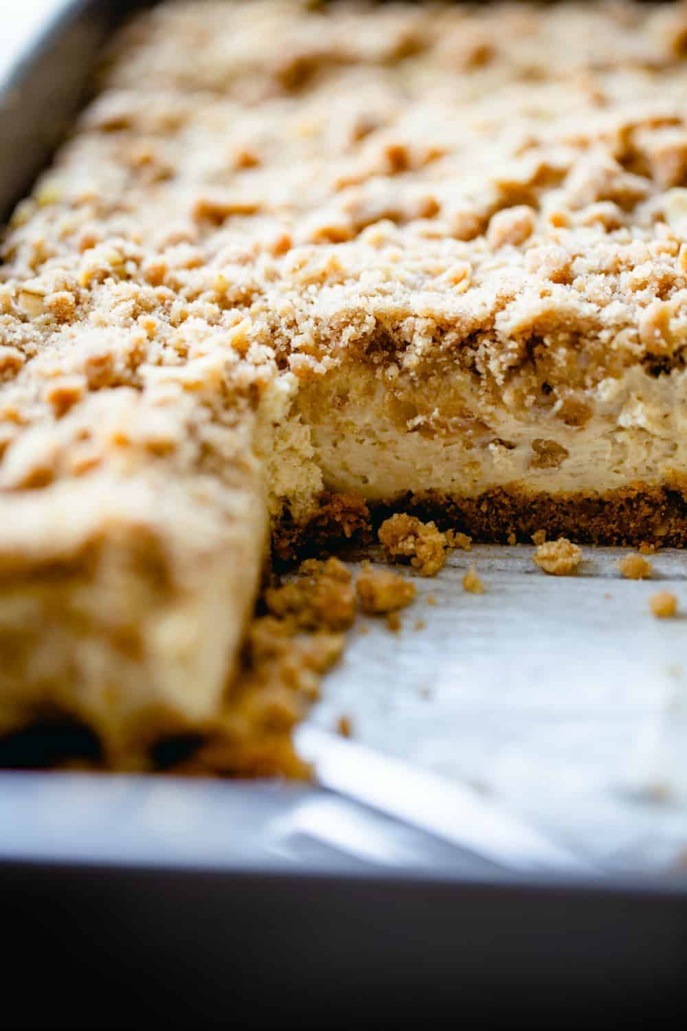 Side view of a pan of maple cheesecake bars with a slice taken out