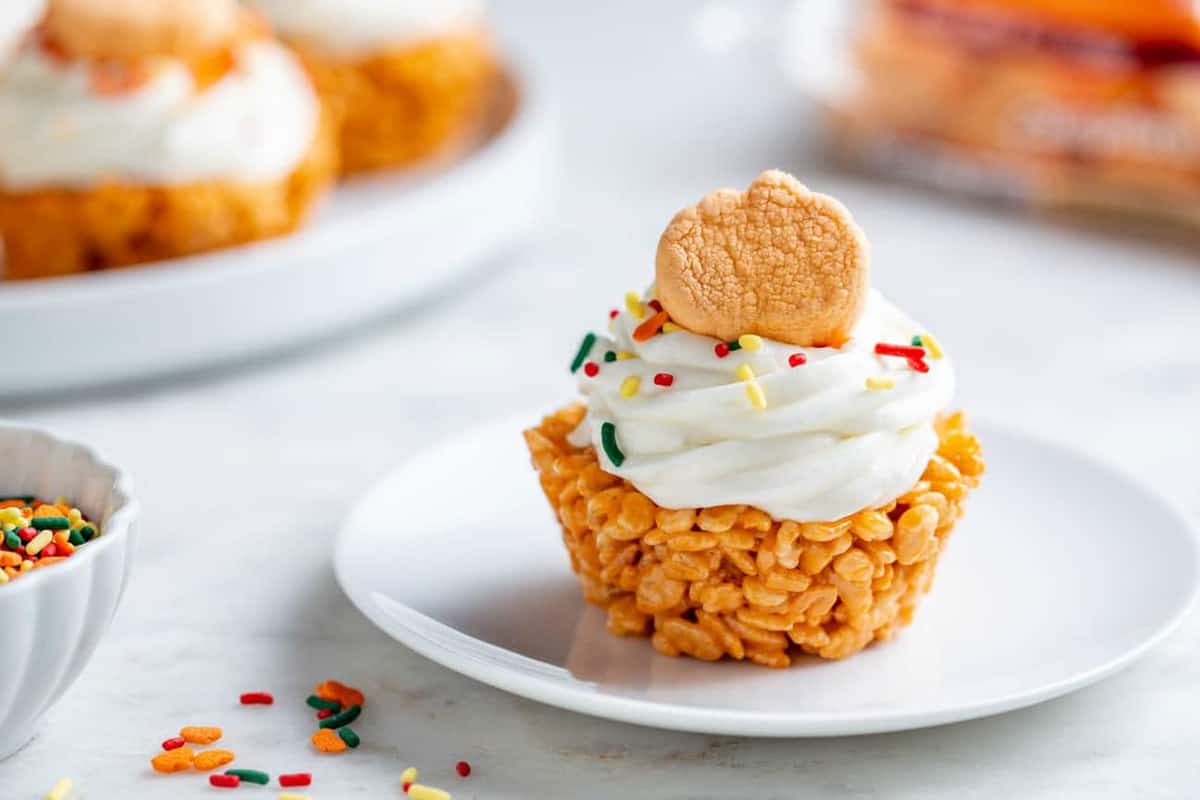 Plated marshmallow treat cupcake topped with cream cheese icing and a pumpkin spice marshmallow