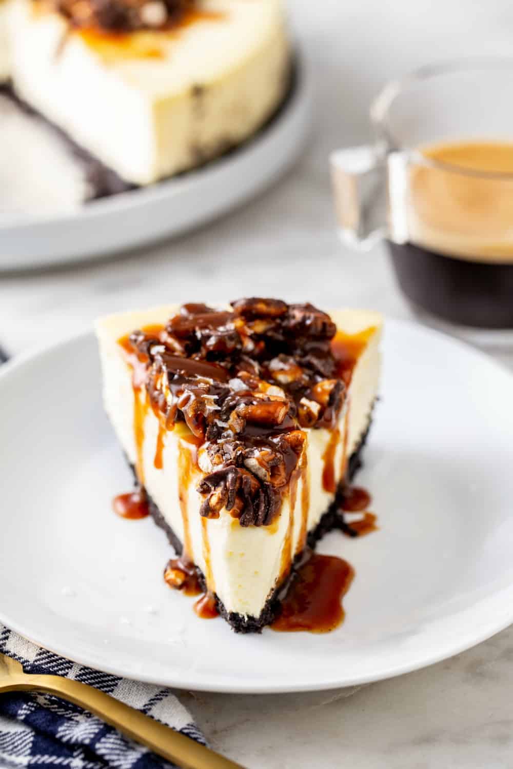 Slice of sweet and salty cheesecake with the remaining cheesecake in the background