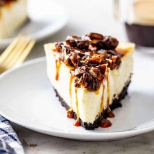 Slice of cheesecake topped with caramel sauce and chopped pretzels