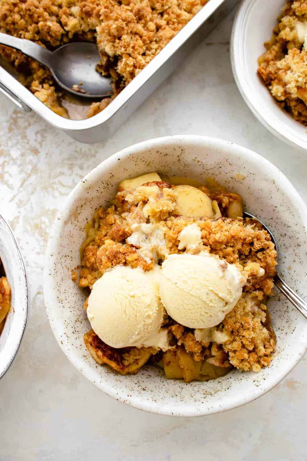 Bowl of old fashioned apple crisp topped with ice cream