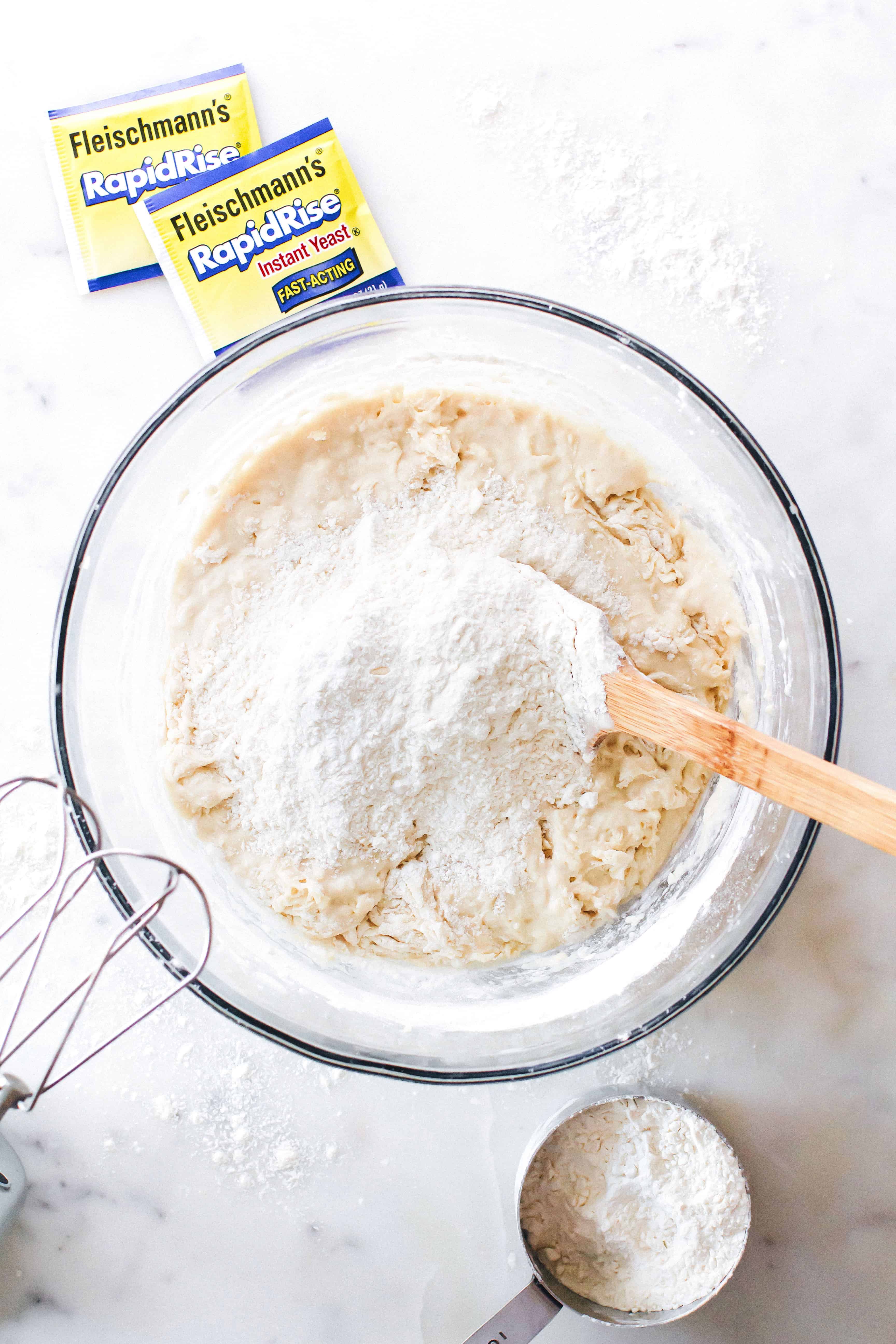 Dough for cinnamon rolls being mixed in a glass bowl