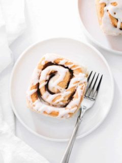 Plated maple chai cinnamon roll on a white plate