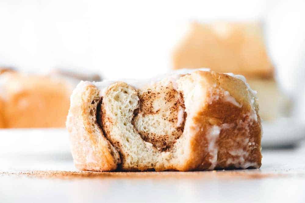 Maple chai cinnamon roll with a bite taken out of it