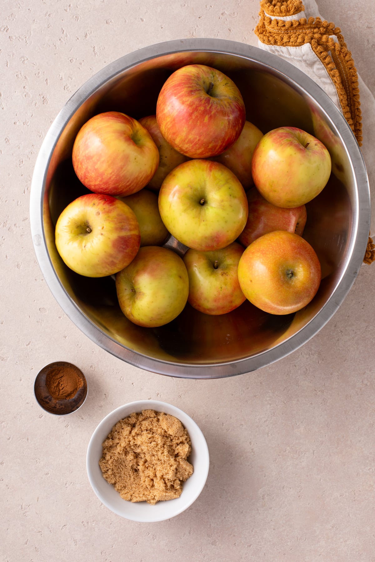 Ingredients for crockpot applesauce arranged on a countertop.