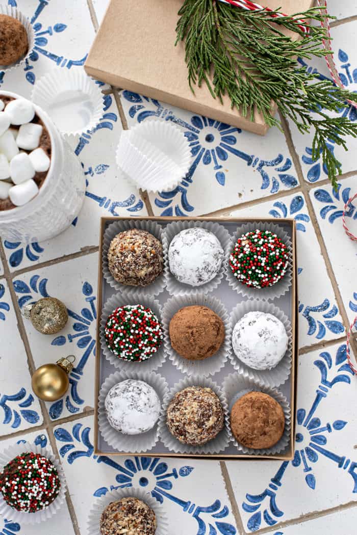 9 rum balls with assorted toppings arranged in a box for gifting