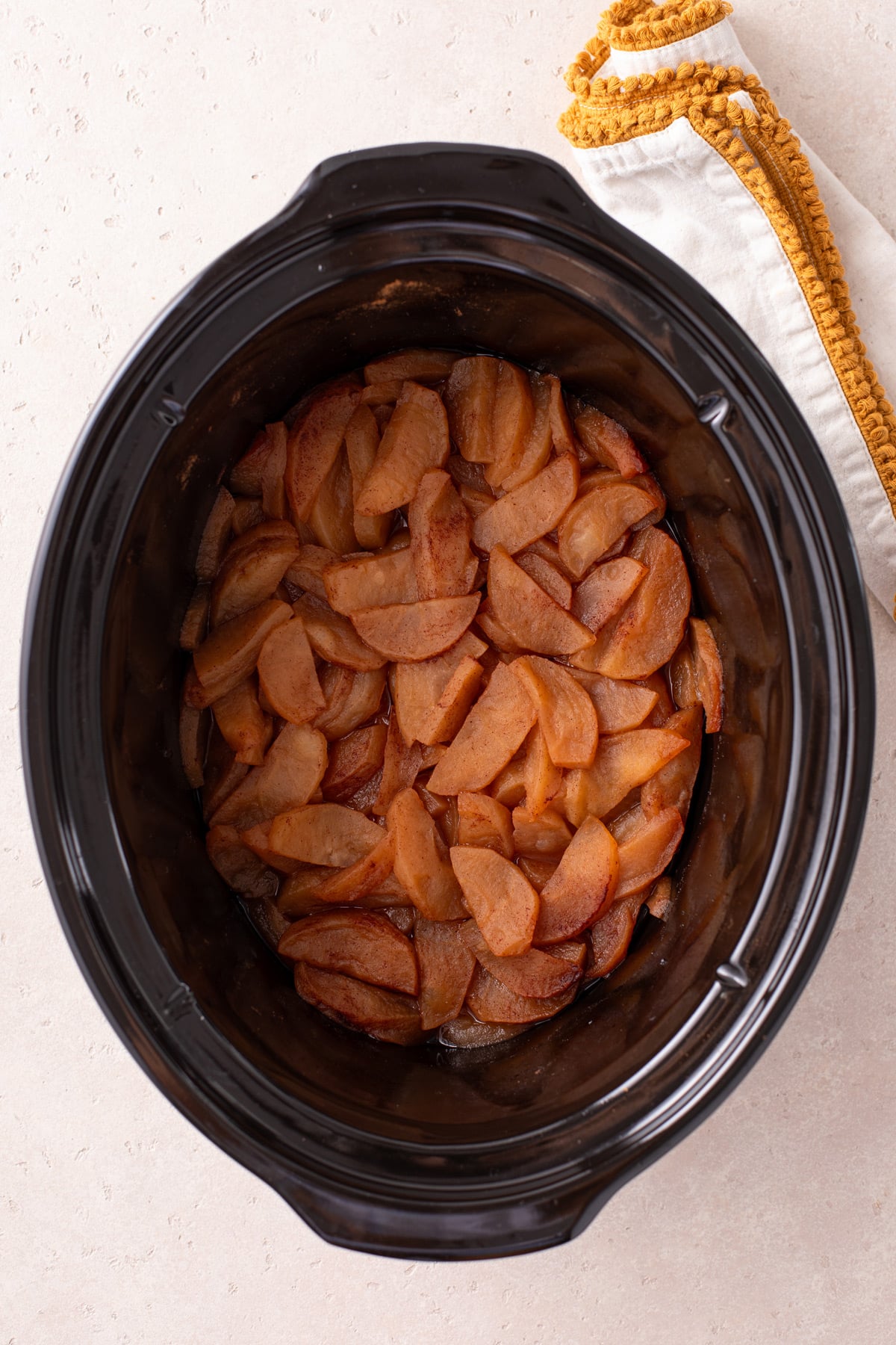 Cooked apples in the crock of a slow cooker.