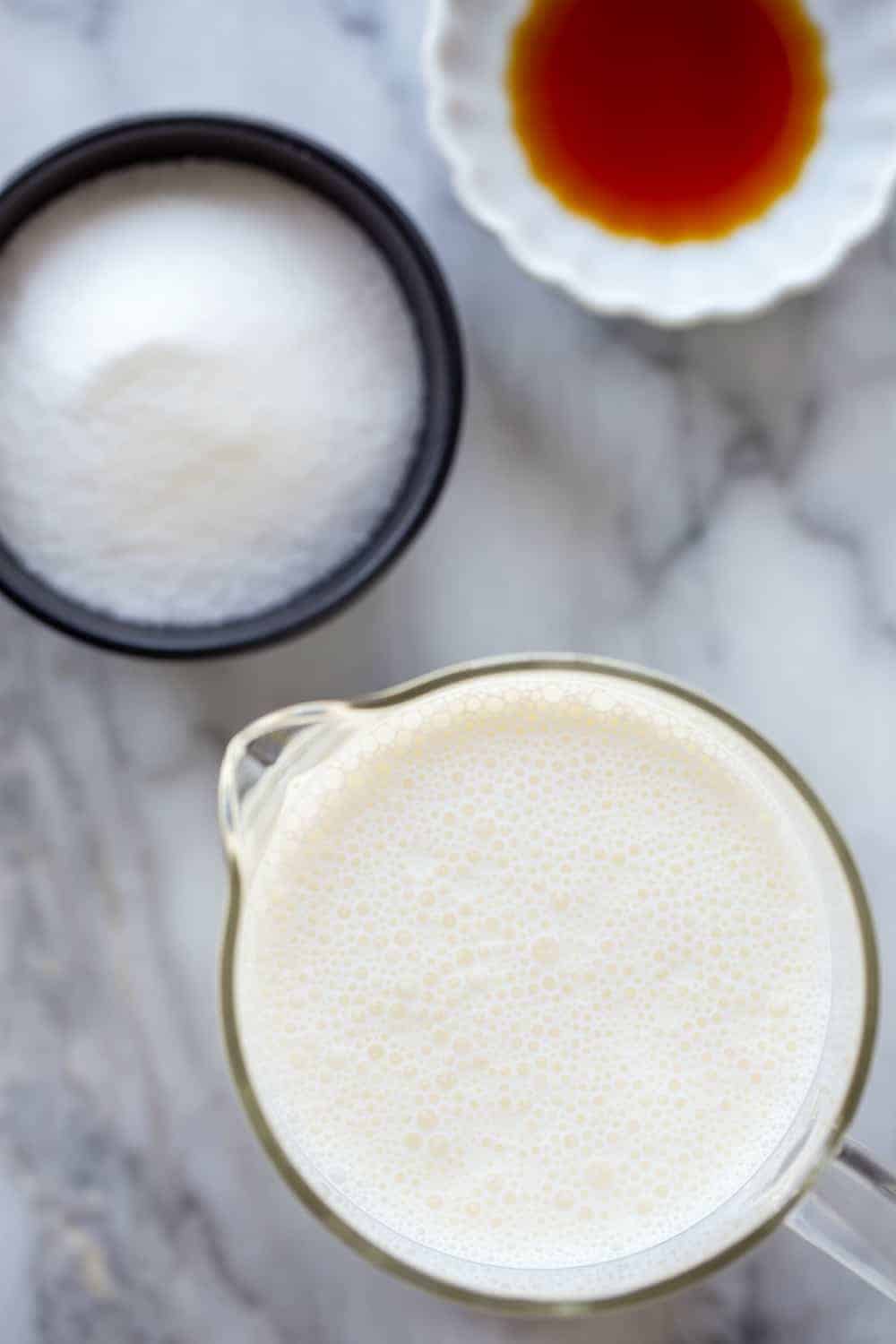 Ingredients for homemade whipped cream on a marble surface